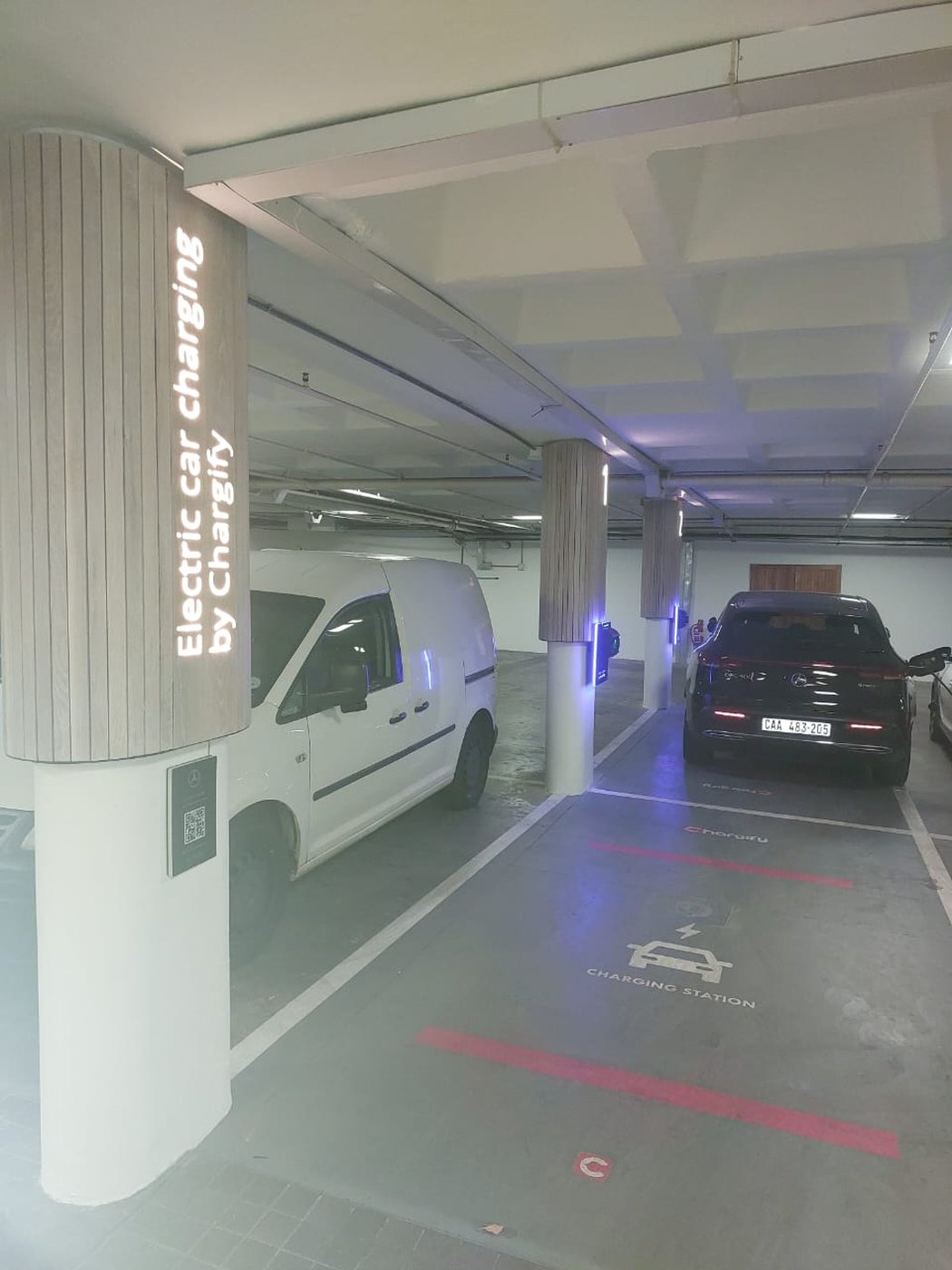 Chargify electric car charging signage and charger in a basement parking garage